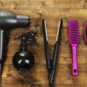 Hairdressing tools on wooden table close-up