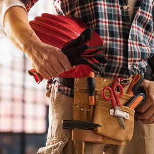 Bricklayer holding construction tools